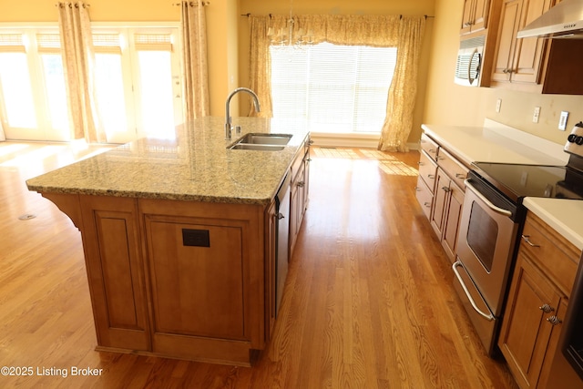 kitchen featuring stainless steel range with electric stovetop, brown cabinetry, a sink, and ventilation hood