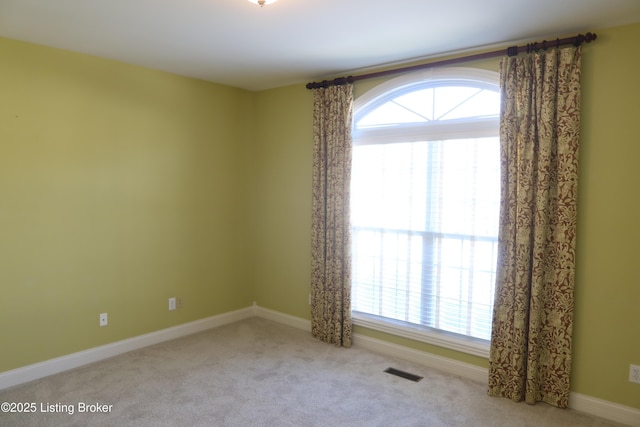 carpeted empty room with visible vents and baseboards