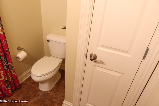 bathroom featuring baseboards, toilet, and tile patterned floors