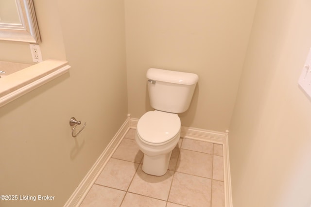 half bathroom featuring baseboards, toilet, and tile patterned floors