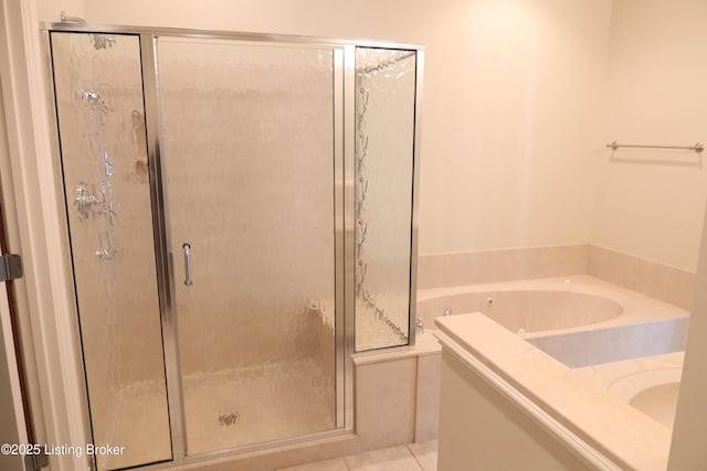 bathroom with a stall shower, tile patterned flooring, and a garden tub