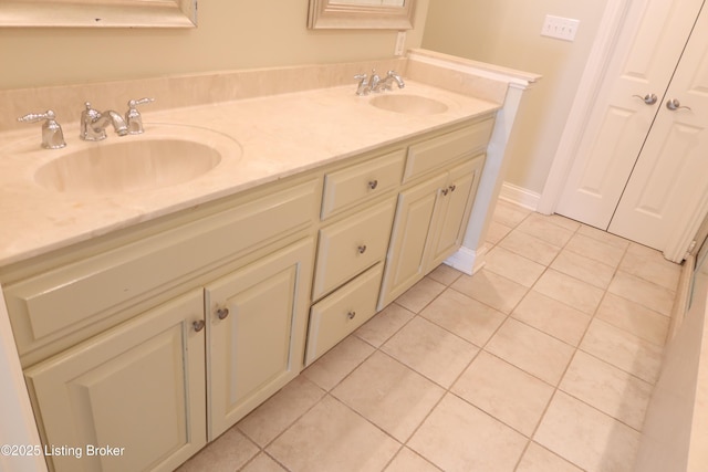 full bathroom featuring baseboards, double vanity, a sink, and tile patterned floors