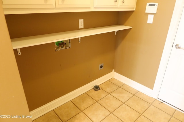 laundry area featuring light tile patterned floors, cabinet space, baseboards, hookup for a washing machine, and electric dryer hookup