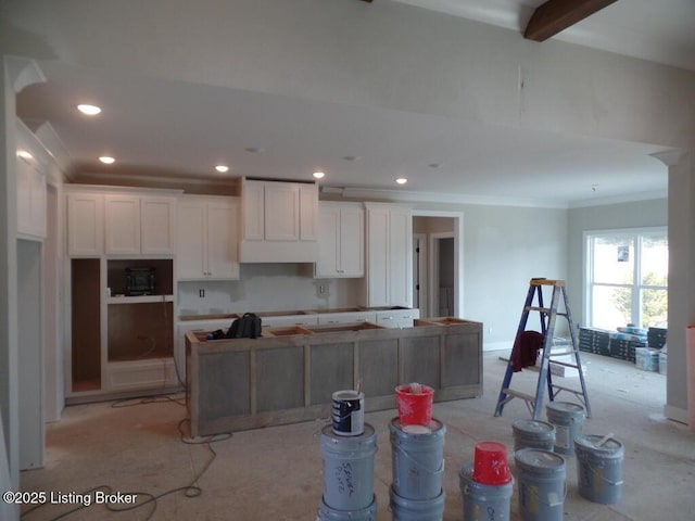 kitchen featuring crown molding, recessed lighting, white cabinets, a kitchen island, and beamed ceiling