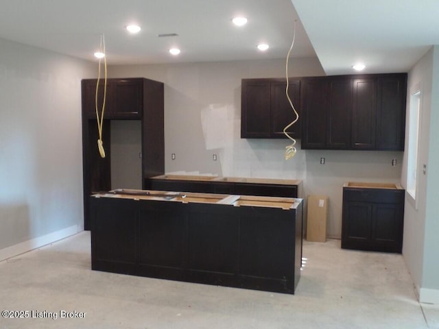 kitchen featuring dark brown cabinetry, a kitchen island, and recessed lighting