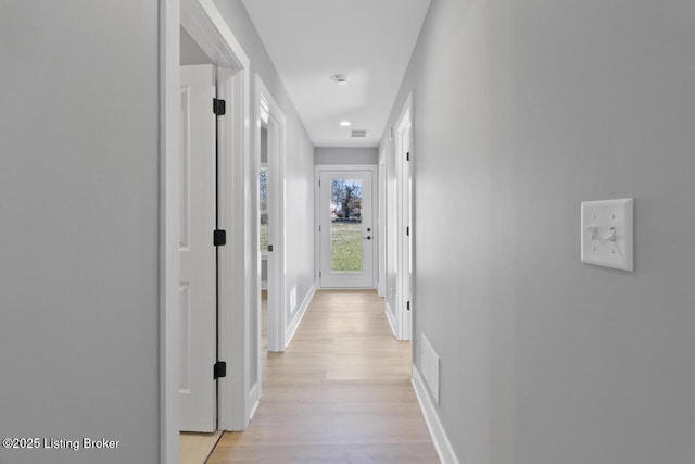 corridor featuring light wood-style floors, visible vents, and baseboards