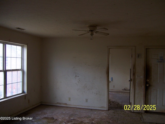 spare room with a healthy amount of sunlight, ceiling fan, and visible vents