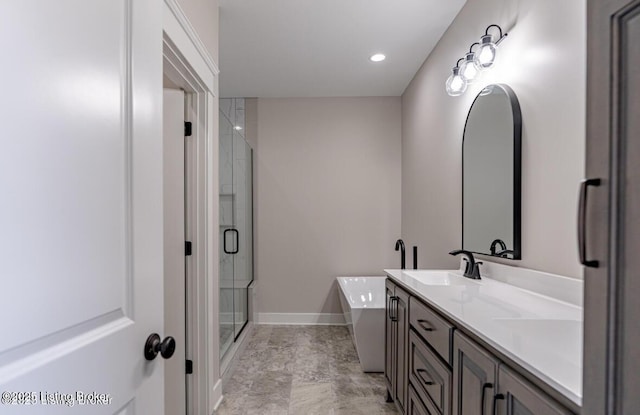 full bath featuring double vanity, recessed lighting, a sink, a shower stall, and a freestanding tub