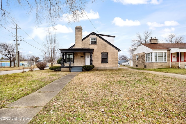 bungalow with a front yard, covered porch, and a chimney