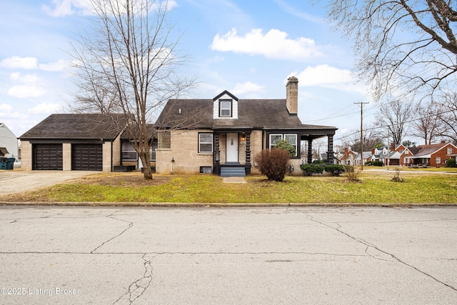 view of front of property with a front lawn, driveway, a chimney, and an attached garage