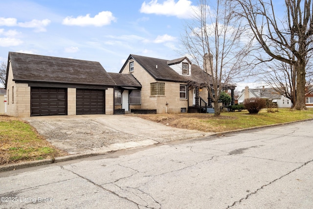 view of front of property with a garage, driveway, and roof with shingles