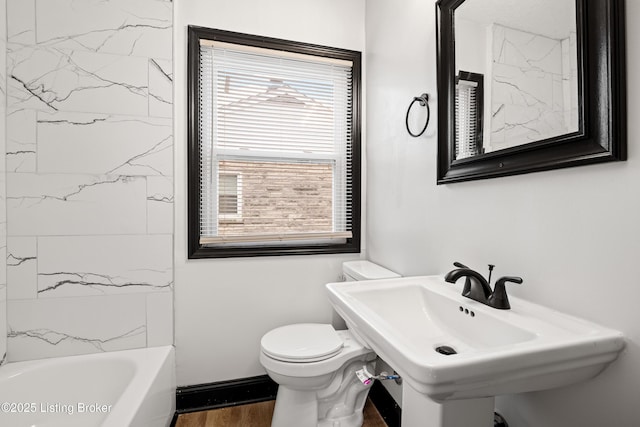 bathroom featuring baseboards, a sink, toilet, and wood finished floors