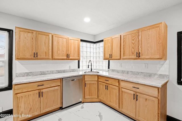 kitchen featuring dishwasher, marble finish floor, a sink, and light brown cabinets