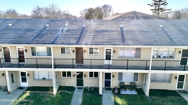 view of front facade featuring a shingled roof and brick siding