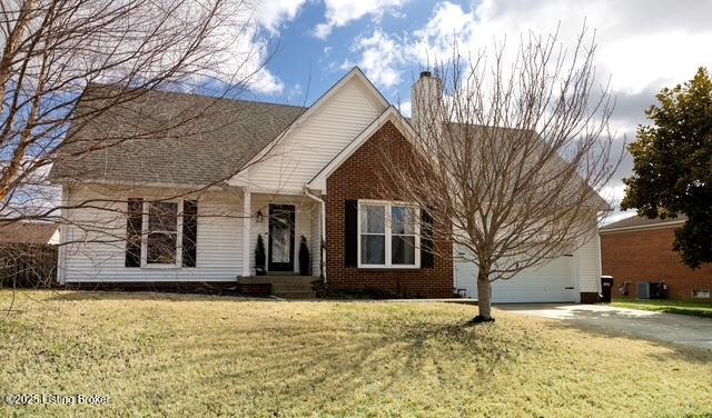 view of front of house with driveway, a garage, a chimney, a front lawn, and brick siding