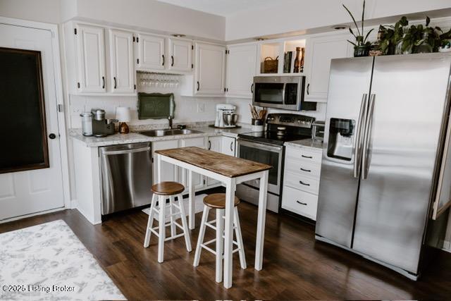 kitchen with tasteful backsplash, white cabinets, appliances with stainless steel finishes, light countertops, and a sink