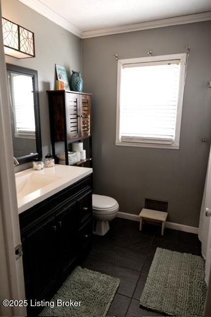 bathroom featuring toilet, baseboards, crown molding, and vanity