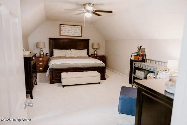 bedroom featuring a ceiling fan, light carpet, vaulted ceiling, and baseboards