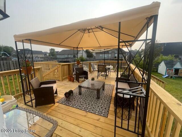 wooden deck with outdoor dining area and a gazebo