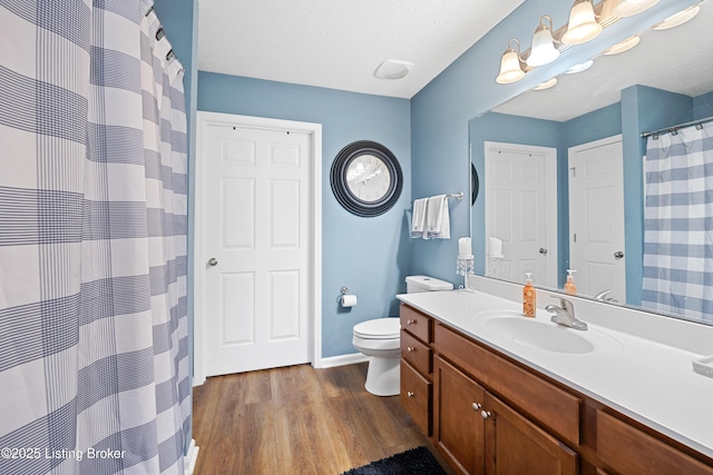 full bath featuring baseboards, toilet, wood finished floors, curtained shower, and vanity