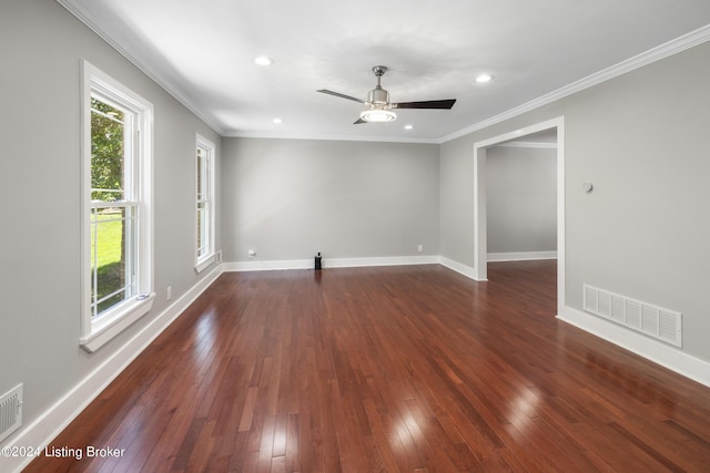 spare room featuring dark wood-type flooring, visible vents, and baseboards