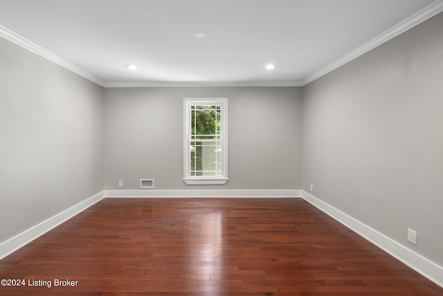 unfurnished room with baseboards, crown molding, visible vents, and wood finished floors