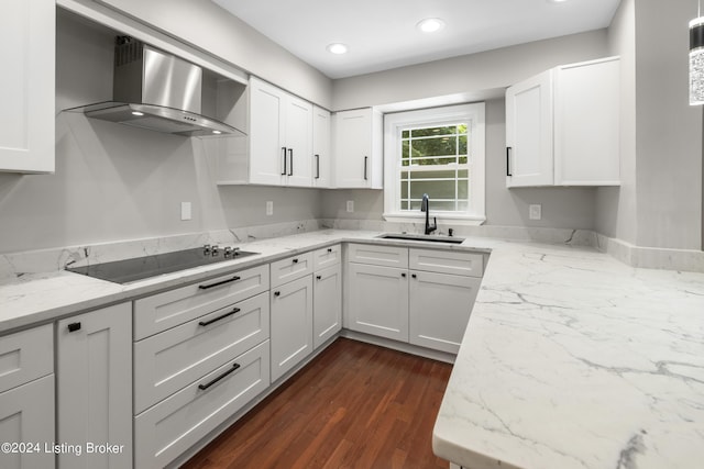 kitchen with black electric cooktop, recessed lighting, a sink, white cabinets, and wall chimney range hood