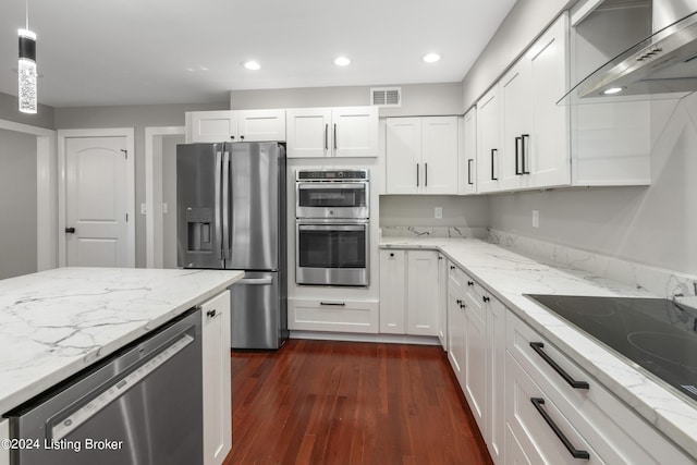 kitchen featuring dark wood-style flooring, visible vents, white cabinetry, appliances with stainless steel finishes, and wall chimney exhaust hood