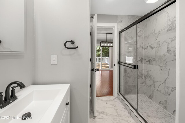 bathroom with marble finish floor, vanity, and a marble finish shower