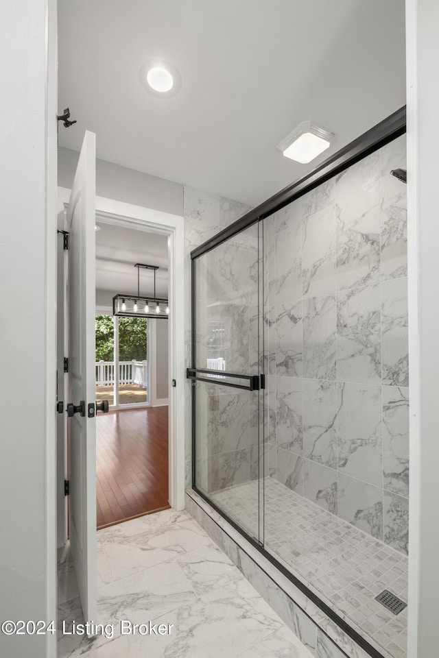 bathroom with marble finish floor and a shower stall