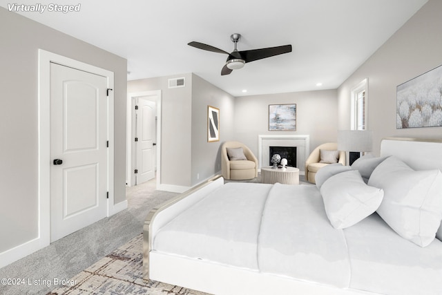 bedroom with baseboards, visible vents, a ceiling fan, a fireplace with raised hearth, and carpet flooring