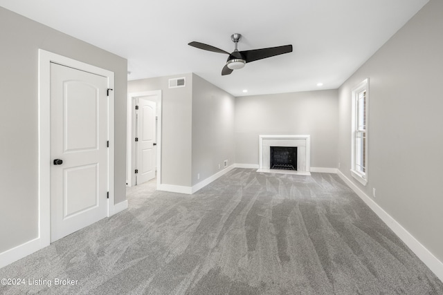 unfurnished living room with carpet floors, recessed lighting, visible vents, a fireplace with flush hearth, and baseboards