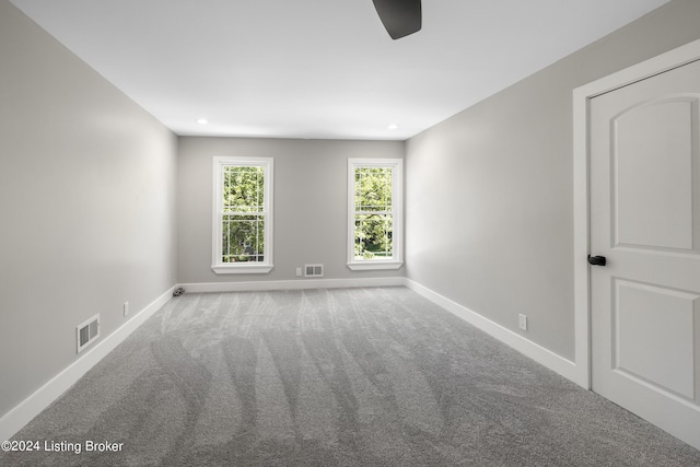 empty room with carpet floors, recessed lighting, visible vents, and baseboards