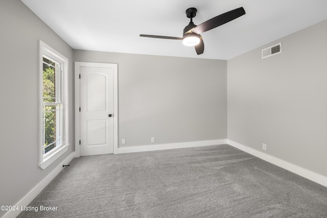 spare room featuring a wealth of natural light, carpet flooring, and visible vents