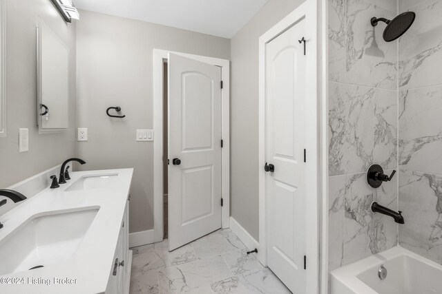 bathroom with marble finish floor, shower / bathing tub combination, a sink, and baseboards