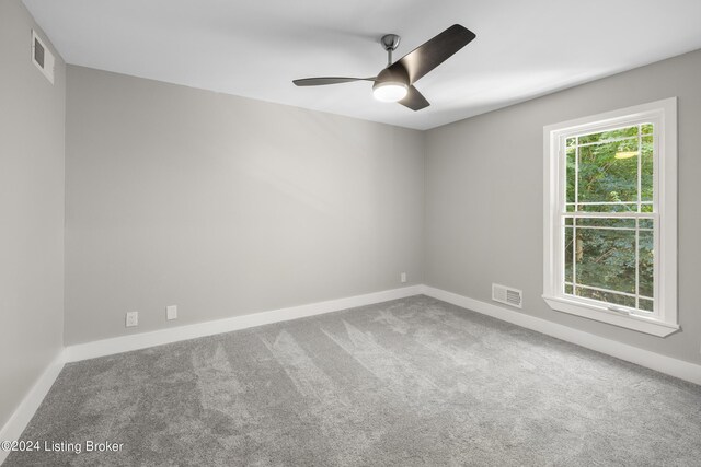 spare room with baseboards, visible vents, and carpet flooring