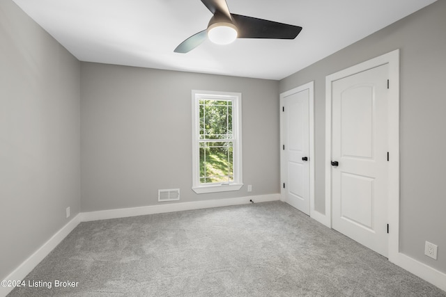 unfurnished bedroom with baseboards, visible vents, ceiling fan, and carpet flooring