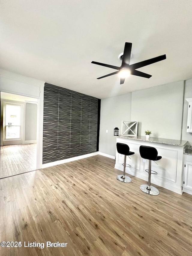 interior space with light wood-style floors, ceiling fan, and baseboards