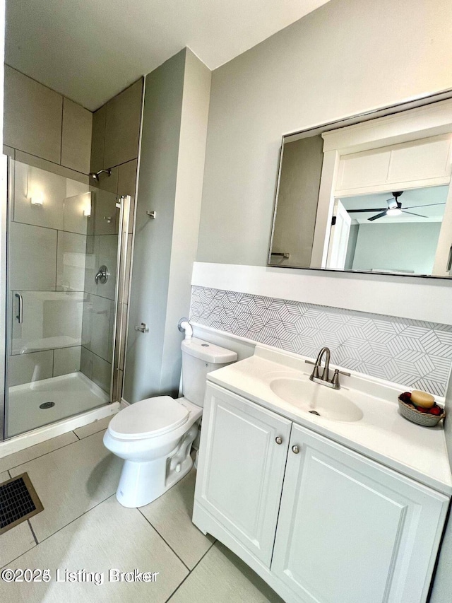 full bathroom featuring toilet, ceiling fan, a shower stall, vanity, and tile patterned flooring