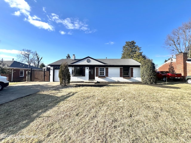 ranch-style home with a garage, a front yard, and driveway