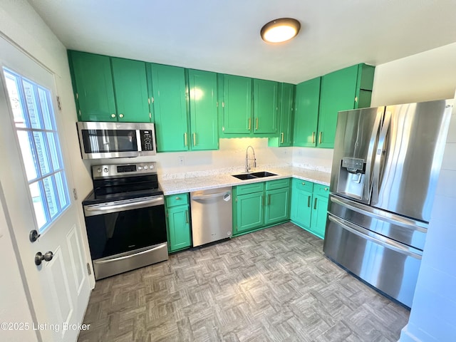 kitchen featuring a sink, stainless steel appliances, light countertops, light floors, and green cabinetry