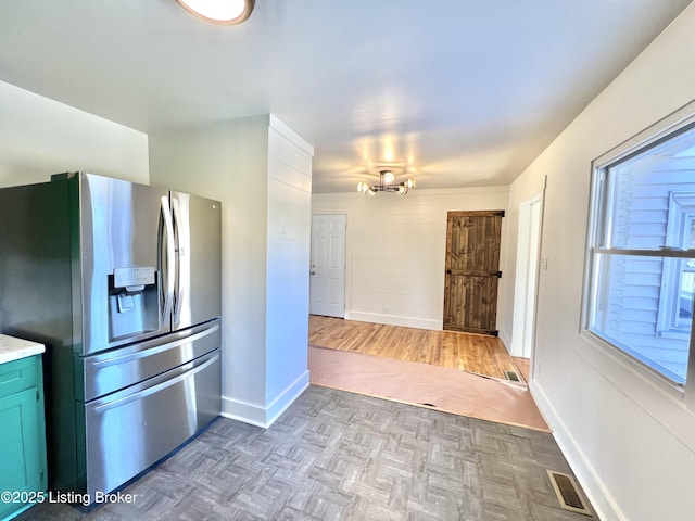 kitchen featuring light countertops, plenty of natural light, visible vents, and stainless steel fridge with ice dispenser