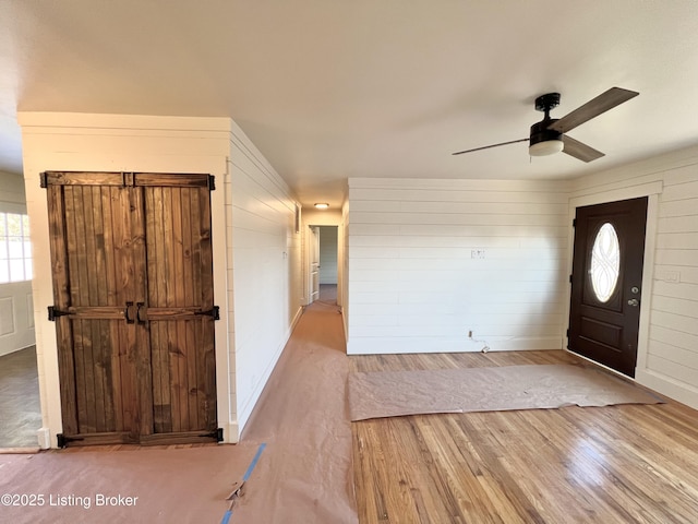 entryway with a ceiling fan, baseboards, and wood finished floors