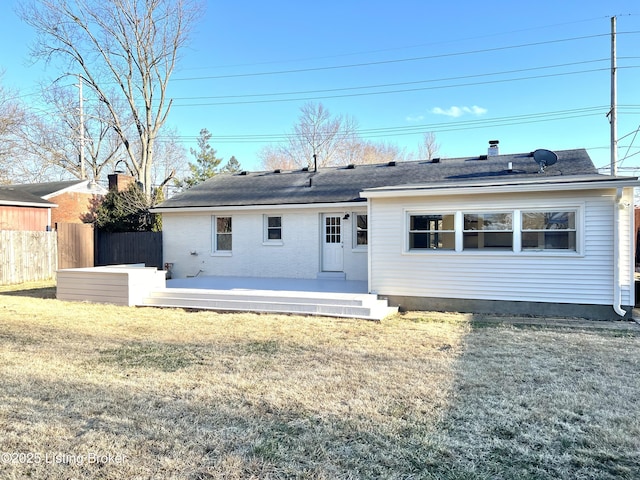 back of house with a lawn and fence