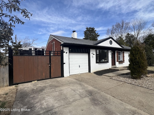 view of front of property with brick siding, a chimney, an attached garage, a gate, and driveway