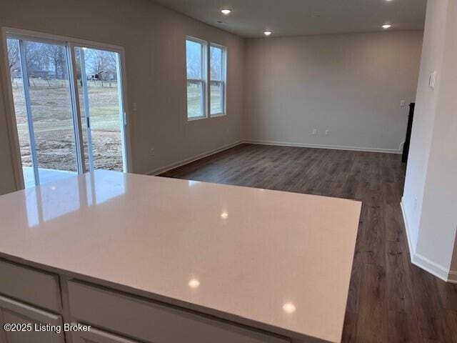 kitchen with recessed lighting, light countertops, dark wood finished floors, and baseboards