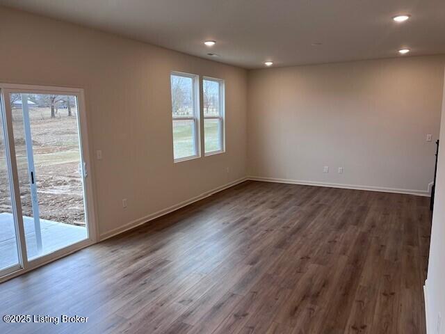 spare room featuring dark wood-style floors, baseboards, and recessed lighting