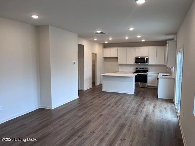 kitchen with light countertops, visible vents, appliances with stainless steel finishes, dark wood-type flooring, and a sink