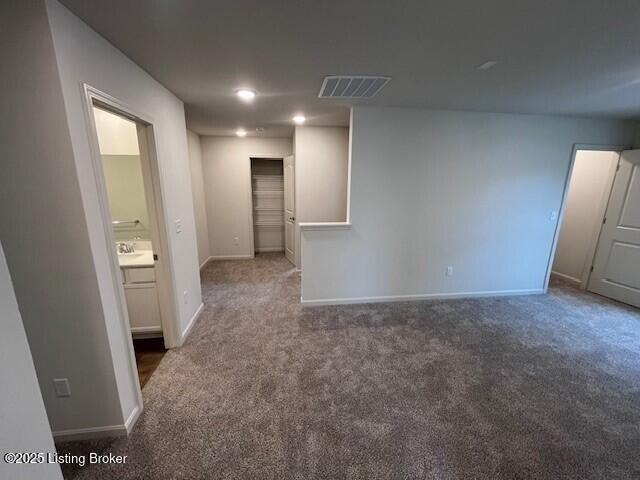 empty room featuring carpet flooring, visible vents, and baseboards