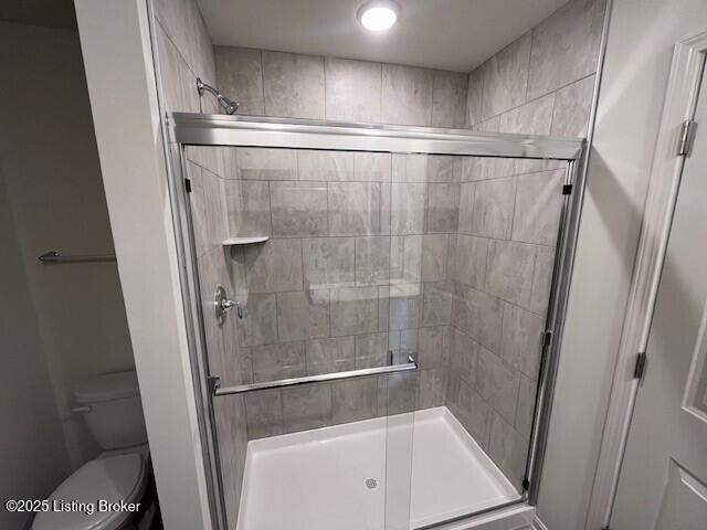 bathroom with a stall shower and toilet